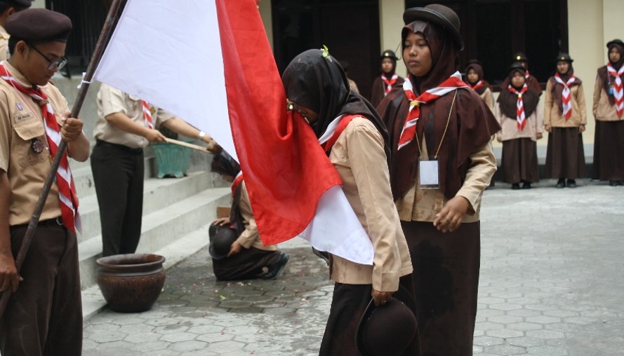 Peserta mencium bendera merah putih saat upacara pelantikan tamu racana